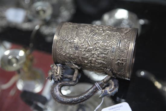 A mid-19th century Chinese silver mug, the body featuring warriors fighting to one side, with inscribed shield plaque H.13cm.